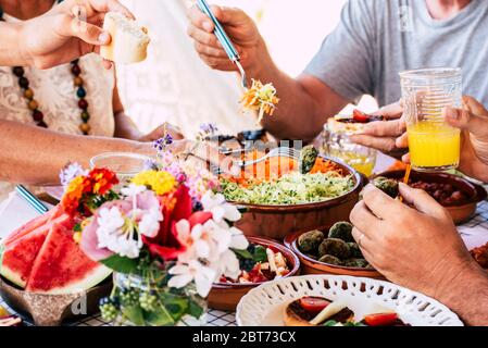 Famille à la scène de déjeuner avec des âges différents caucasiens méconnus les gens mangeant et buvant ensemble ayant du plaisir pour la tradition ou célébrant des moments - c Banque D'Images