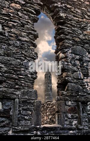 La tour ronde qui fait partie du monastique demeure à Glendalough, dans le comté de Wicklow. Ce premier établissement ecclésiastique chrétien a été fondé Banque D'Images