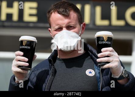 Albert Martin, qui est propriétaire et responsable du pub Willows à Glasnevin, se prépare à livrer deux pintes de Guinness alors que le pub a commencé un service de livraison dans un rayon d'un kilomètre des locaux. Banque D'Images