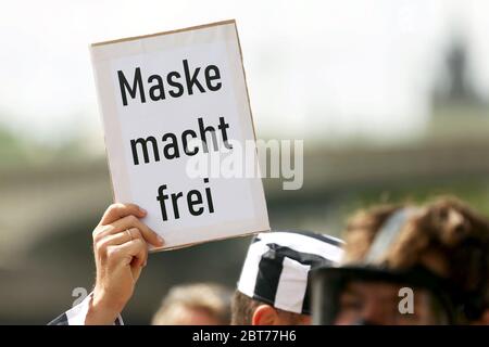 Cologne, Allemagne. 23 mai 2020. Lors d'une manifestation contre les restrictions de Corona, un manifestant en costume de prisonnier tient une affiche avec l'inscription « Ask power free ». L'homme était contrôlé par la police et a quitté la manifestation après avoir été identifié. Crédit : David Young/dpa/Alay Live News Banque D'Images