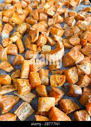 Morceaux de patate douce à l'orange fraîchement cuits avec assaisonnement au romarin Banque D'Images