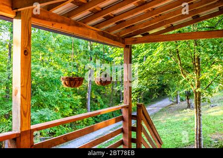 Plantes en pot suspendues pots de fleurs avec feuilles de fleurs violettes au printemps avec arrière-plan bokeh sur le porche de chalet maison de chalet avec la couleur verte et non Banque D'Images