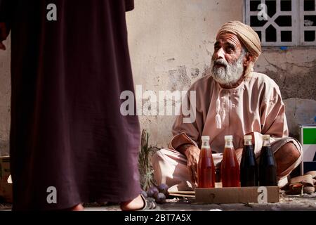 Vieux omanais vendant du miel et de l'ail sur le marché traditionnel ou souq à Nizwa, Oman. Belle photo éditoriale, photo de rue Banque D'Images