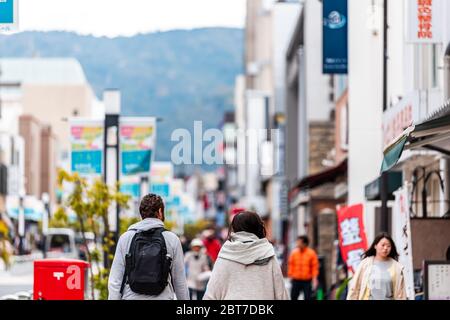 Nara, Japon - 14 avril 2019: Personnes étrangers touristes marchant sur la rue trottoir dans le centre-ville vers le parc avec des magasins et des panneaux Banque D'Images