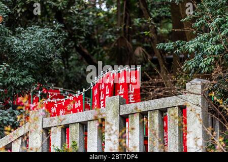 Tokyo, Japon - 31 mars 2019 : bannières de drapeaux rouges appelées nobori à l'entrée du sanctuaire HIE dans le quartier de quartier d'Akasaka avec escalier de chemin dans la forêt Banque D'Images