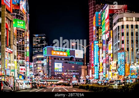Tokyo, Japon - 3 avril 2019 : avenue Yasukuni avec voitures gens près de la rue Kabukicho Alley dans le centre-ville avec lumières de nuit néons paysage urbain Banque D'Images