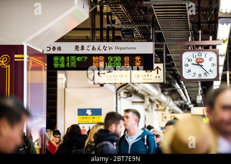 Utsunomiya, Japon - 5 avril 2019: Gare plate-forme ligne locale à Nikko signe en japonais avec beaucoup de gens attendent par les voies et l'horloge Banque D'Images