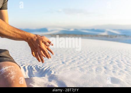 Monument national des dunes de sable blanc avec homme main tenant sable tombant grains au Nouveau-Mexique au coucher du soleil Banque D'Images