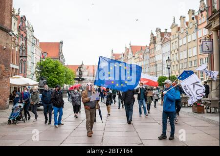 Des manifestants marchant avec des drapeaux le long de la rue Dluga pendant la manifestation.le Komitet Obrony Demokracji (Comité de défense de la démocratie) a exprimé son opposition à des violations de la loi et des normes démocratiques en Pologne où la pandémie a été utilisée pour restreindre illégalement les libertés et libertés civiles. Banque D'Images