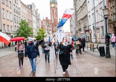 Des manifestants marchant avec des drapeaux le long de la rue Dluga pendant la manifestation.le Komitet Obrony Demokracji (Comité de défense de la démocratie) a exprimé son opposition à des violations de la loi et des normes démocratiques en Pologne où la pandémie a été utilisée pour restreindre illégalement les libertés et libertés civiles. Banque D'Images