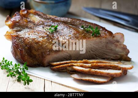 Épaule de porc cuite sur l'os avec des épices, des herbes et de l'huile aromatique. Banque D'Images