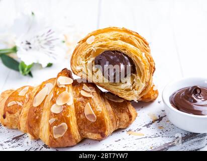 Croissant frais délicieux, amandes en tranches, avec garniture au chocolat coupée, gros plan Banque D'Images
