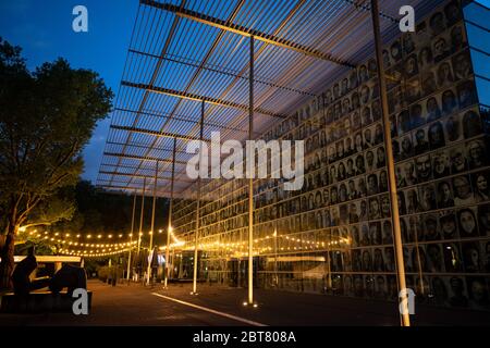 Recklinghausen, Allemagne. 23 mai 2020. Des photos grand format de personnes qui se seraient réunies au cours de ces semaines au célèbre Theatertreffen pendent sur la façade de la Ruhrfestspielhaus. Les visiteurs et les artistes ont envoyé des photos de portrait de leur isolement, qui ont ensuite fait partie du projet « Inside Out » de l'artiste français JR. Le festival de théâtre avait été annulé à cause de la crise de Corona. À gauche, la sculpture grand inclinable Figure no 5 du sculpteur Henry Moore. Crédit : Bernd Thissen/dpa/Alay Live News Banque D'Images