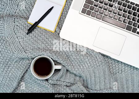 Plat de travail confortable avec café chaud, ordinateur portable, bloc-notes. Travail à la maison. Écriture. Banque D'Images