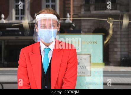 Le personnel de Fortnum & Mason portant des masques et des visières accueille les clients dans son magasin phare de Piccadilly après avoir rouvert son Food Hall, Londres, Royaume-Uni Banque D'Images