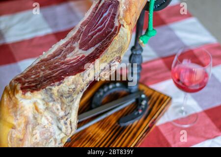 Serrano jambon sur un support fait avec des fers à cheval et un verre de vin rose Banque D'Images