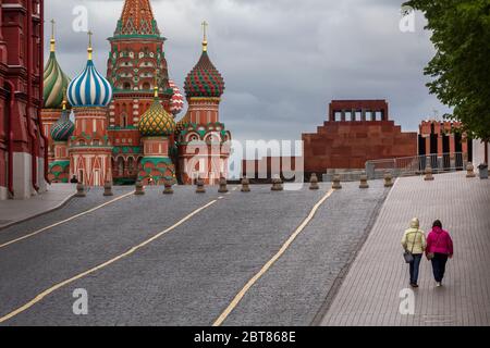 Les femmes marchent le long d'une place rouge vide dans le centre de Moscou, Russie Banque D'Images