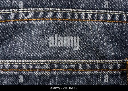Vêtements en coton bleu jean délavé tissu stonewashed texture avec coutures, fermoirs, boutons et rivets, macro, close-up Banque D'Images
