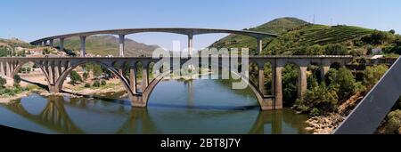 Ponts traversant le fleuve Douro à l'est de Porto dans la région viticole portugaise, vignobles en terrasse sur les pentes en arrière-plan, Peso da Regua, Portugal Banque D'Images