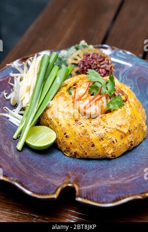 Padthai, nouilles de riz poêlées de style thaïlandais avec sauce tamarin, servir avec une couverture de crevettes tigrées grillées avec omelette.recette de cuisine gastronomique thaïlandaise Restaura Banque D'Images