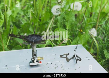 brûleur à gaz touristique sur une petite table dans l'herbe, concept léger. Banque D'Images