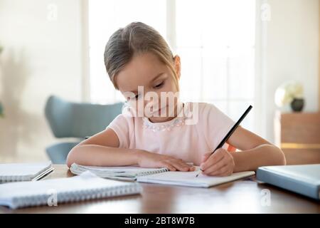 Petite fille intelligente écrire dans le carnet étudiant Banque D'Images