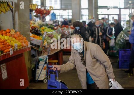 Bucarest, Roumanie - 16 avril 2020 : les personnes âgées portant un masque de protection font leurs courses dans un marché ouvert très fréquenté à Bucarest, pendant l'épidémie de Covid-19 Banque D'Images