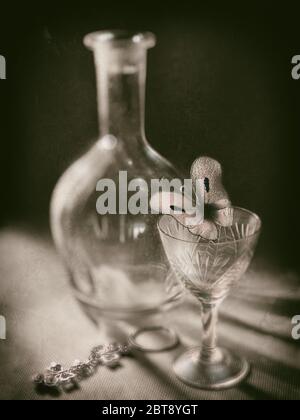 La vie artistique encore dans le style rétro. Carafe en verre, lunettes de vin, papillon, porte-clés en style monochrome Banque D'Images