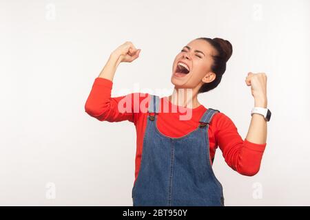 Portrait de la jeune fille enthousiaste et enthousiaste et enthousiaste avec un petit pain en Jean qui hurle de joie, hurle avec euphorie, célébrant la victoire Banque D'Images