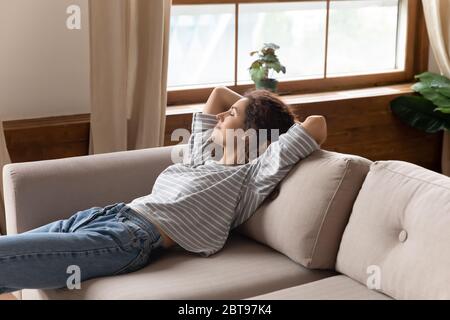Calme paisible jeune femme se reposant sur un canapé confortable seul Banque D'Images