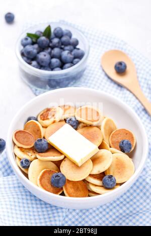 Mini crêpes aux céréales maison avec miel et bleuets sur fond de pierre grise, gros plan, verticales Banque D'Images