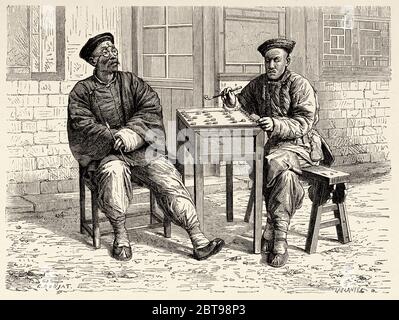 Des personnages chinois jouant aux échecs dans la rue, Chine. Ancienne illustration gravée du XIXe siècle, Voyage à Pékin et Chine du Nord 1873 Banque D'Images