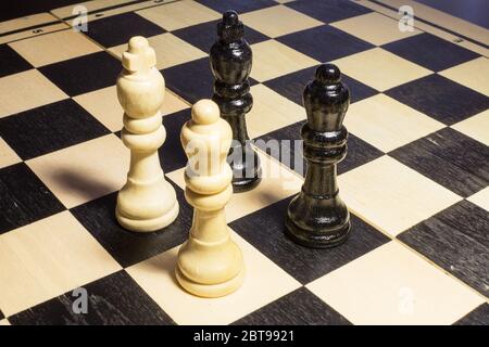 L'échiquier avec le roi blanc et la reine devant les noirs dans le concept de confrontation Banque D'Images