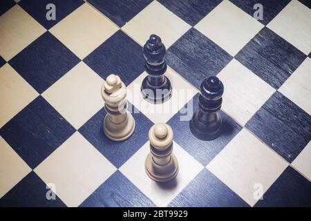 L'échiquier avec le roi blanc et la reine devant les noirs dans le concept de confrontation Banque D'Images