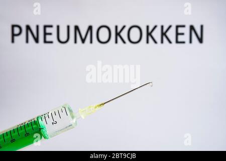 Cette photo montre une seringue jetable avec aiguille hypodermique, PNEUMOKOKEN écrit sur un tableau blanc derrière Banque D'Images