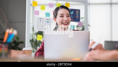 portrait d'une femme leader asiatique souriant lors d'une réunion avec le développeur ux et le concepteur d'interface utilisateur sur la conception filaire de l'interface d'application mobile sur la table de réunion à Banque D'Images