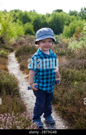 Joyeux petit garçon adorable, de 1 à 2 ans, à pied dans le parc régional d'Alver Valley, Gosport, Hampshire, Angleterre, Royaume-Uni. MODÈLE LIBÉRÉ Banque D'Images