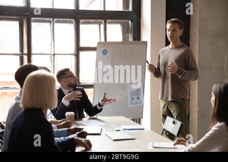 Coach d'affaires répondant aux questions des employés sur le projet lors d'une réunion d'entreprise Banque D'Images