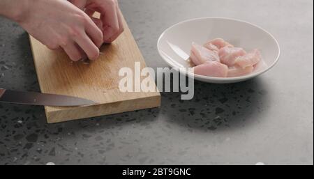 homme mariner à la main des tranches de poulet dans un bol blanc avec des épices Banque D'Images