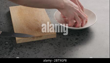homme mariner à la main des tranches de poulet dans un bol blanc avec des épices Banque D'Images