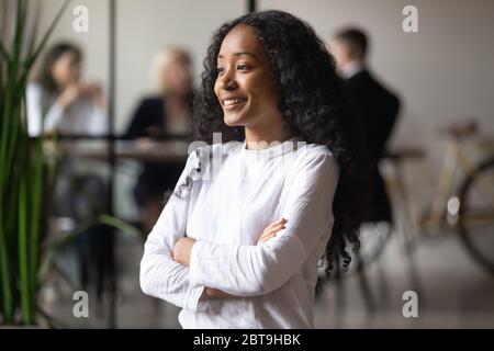 Souriante femme d'affaires afro-américaine rêvant d'un avenir prometteur Banque D'Images