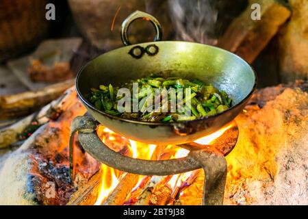 Cuisine de curry de légumes dans la cuisine extérieure sur le bois de feu dans le village local du Népal. Banque D'Images