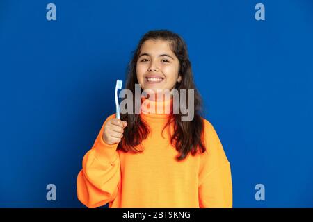 Adorable jeune fille de prètine avec jersey jaune sur fond bleu Banque D'Images