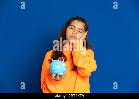 Adorable jeune fille de prètine avec jersey jaune sur fond bleu Banque D'Images