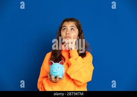 Adorable jeune fille de prètine avec jersey jaune sur fond bleu Banque D'Images