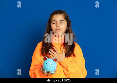 Adorable jeune fille de prètine avec jersey jaune sur fond bleu Banque D'Images