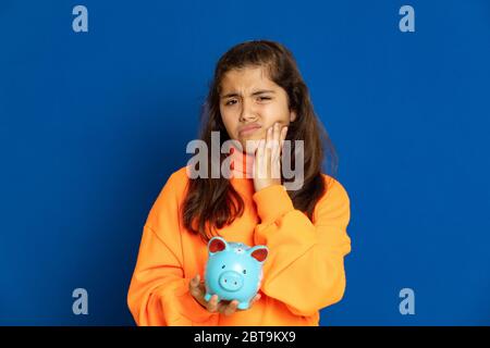 Adorable jeune fille de prètine avec jersey jaune sur fond bleu Banque D'Images