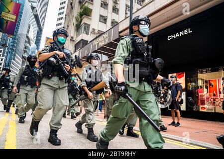 Des policiers anti-émeutes marchent vers les manifestants avec leurs armes lors de la manifestation contre le projet de loi de sécurité nationale.des milliers de manifestants pro-démocratie tentèrent de marcher contre le projet de loi de sécurité nationale rédigé par le Congrès national du peuple à Beijing. La police a arrêté plus de 100 manifestants pour rassemblement illégal. Banque D'Images