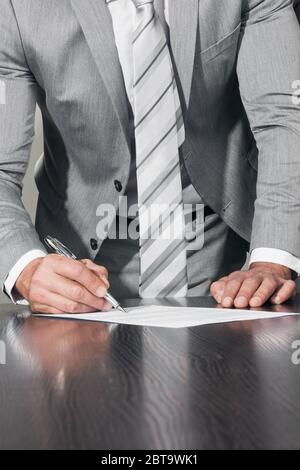 Processus de travail et concept de transaction. Homme d'affaires avec un stylo à la main lisant le contrat officiel d'affaires avant de faire une affaire et de signer le document, de gros plan vie Banque D'Images