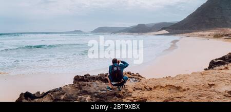 Calhau, île de Sao Vicente Cap-Vert. Photographe avec appareil photo dans le désert admettant un paysage unique de dunes de sable falaises volcaniques sur l'Atlantique Banque D'Images